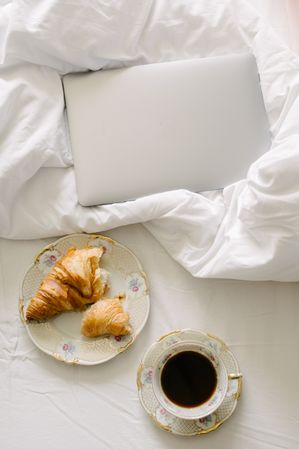 Breakfast with coffee and croissant in bedroom