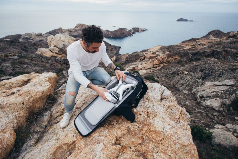 Man unloading bag with drone equipment on the coast