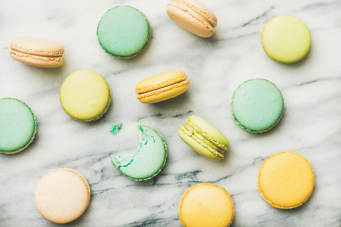 Scattered pastel macaron pastries, top view, horizontal composition