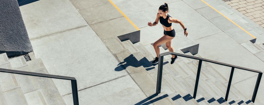 Young woman running up the steps as exercise routine