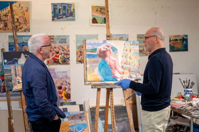 Two men talking in art studio