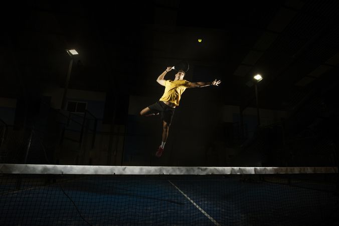 Man playing padel in darkness