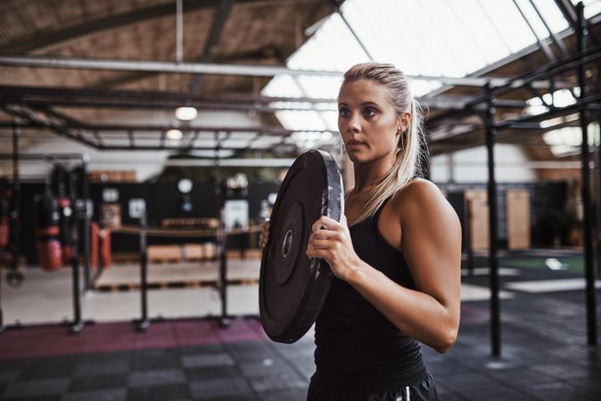 Woman lifting barbell weights in gym