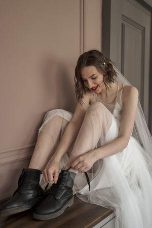 Adult confident bride in white dress and military shoes