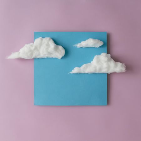 Blue paper with clouds on light purple background