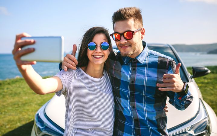 Young couple doing a selfie on the car