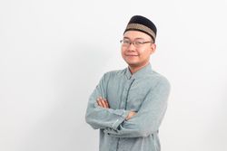 Confident Asian Muslim man smiling crossing hand gesture in Ramadan