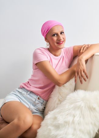 portrait of Woman sick with cancer with pink scarf sitting relaxed optimistic positive