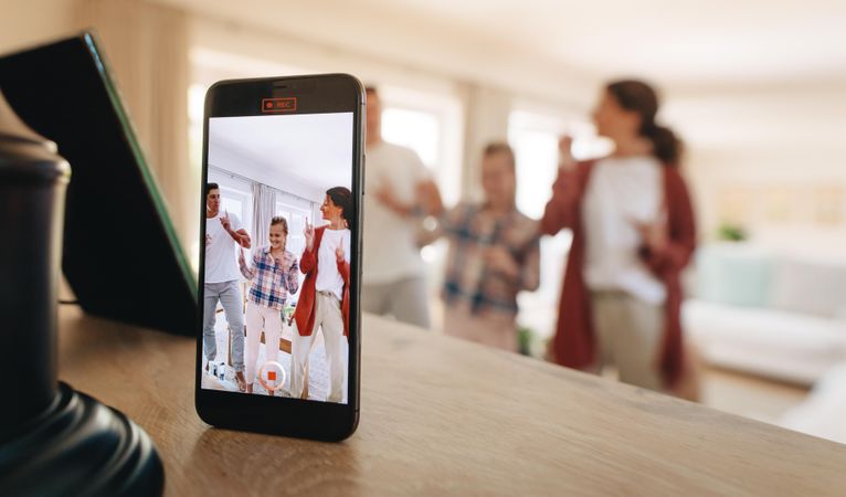 Family dancing in front of the phone indoors