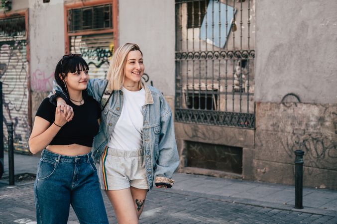 Lesbian couple hugging and walking on street
