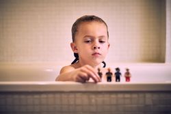Boy in bathroom playing with toys