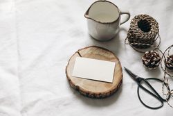 Christmas table setting of blank business card mockup on wooden board