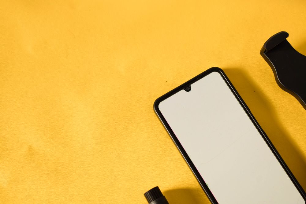 Mock up phone on yellow table with shadow and copy space
