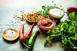 Traditional Georgian sauces tomato satsebeli, yellow and red tkemali with ingredients on counter