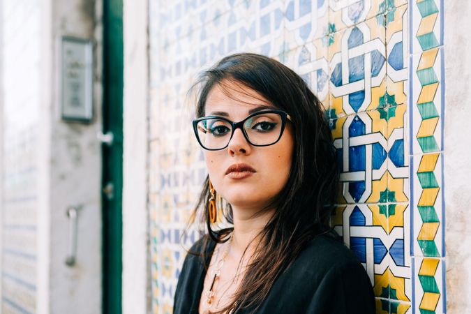 female holding hair against tiled wall