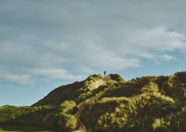 Person on top of a grassy hill