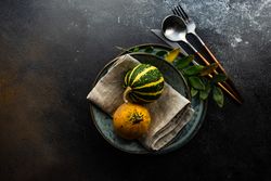 Top view of mini squashes on decorative autumnal table setting