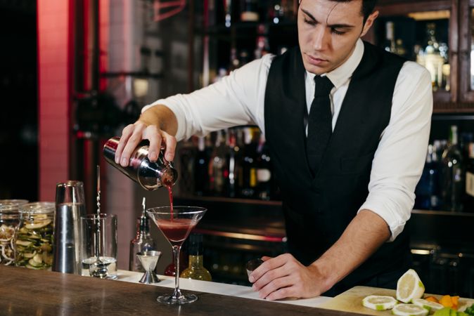 Barman working mixing pouring drink in a glass