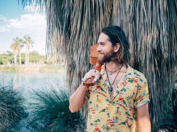Hipster man in jungle with ukulele