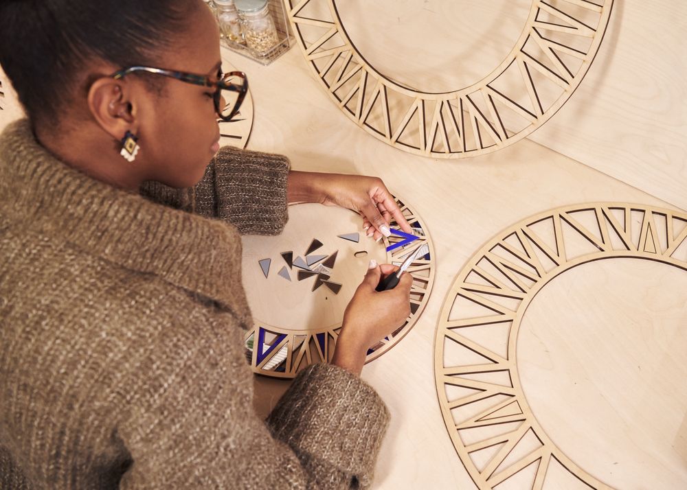 Black artist working with pliers and wood