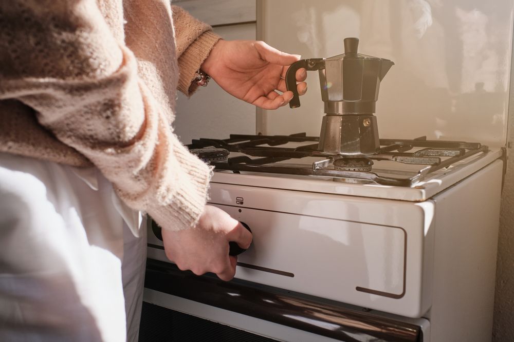 Unrecognizable person preparing coffee in moka pot