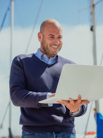 Businessman standing outside looking at the laptop