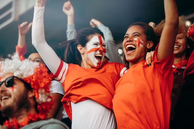 Female soccer fans in stadium celebrating victory
