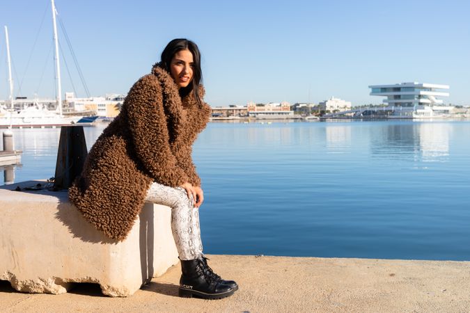 Stylish female sitting in harbor