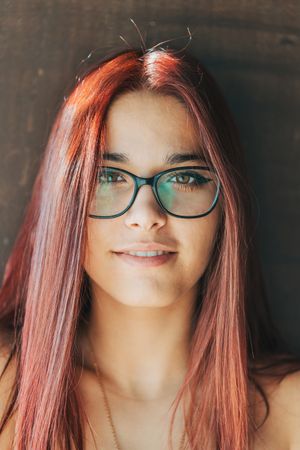 Woman in glasses leaning on wall