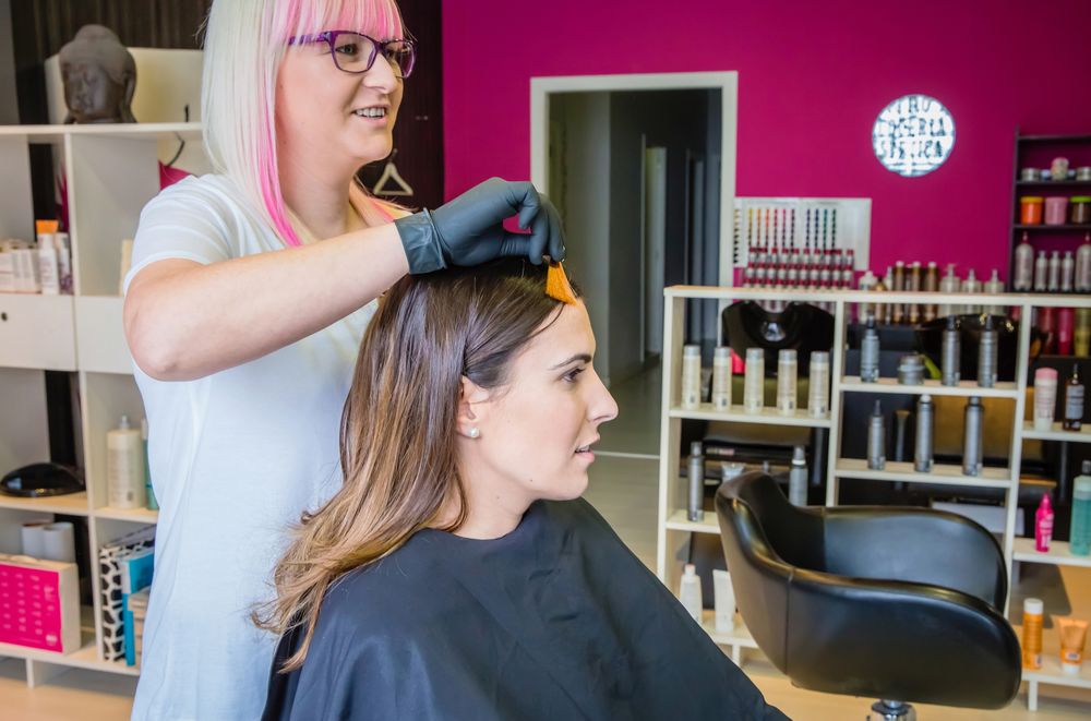 Woman having hair colored in salon