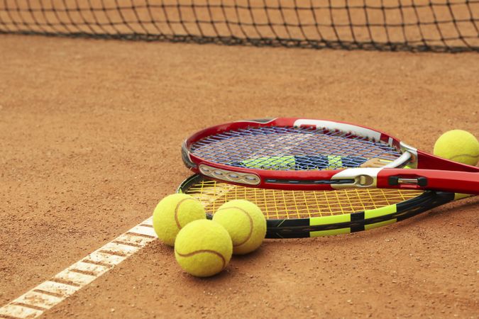 Tennis racquets with tennis balls on clay court