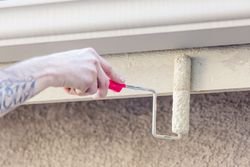 Professional Painter Using Small Roller to Paint House Fascia