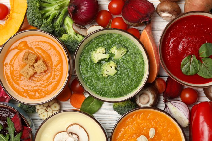 Top view of scattered soups and vegetables with on wooden table