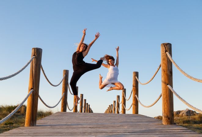 Women posing in air on footbridge