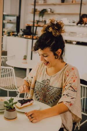 Delighted woman enjoying dessert in cafe