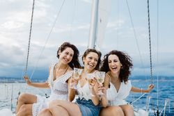 Cheerful friend with wine having fun on yacht