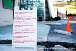 Wide view of sign with instructions for Covid test workers on how to remove PPE 5r9j70