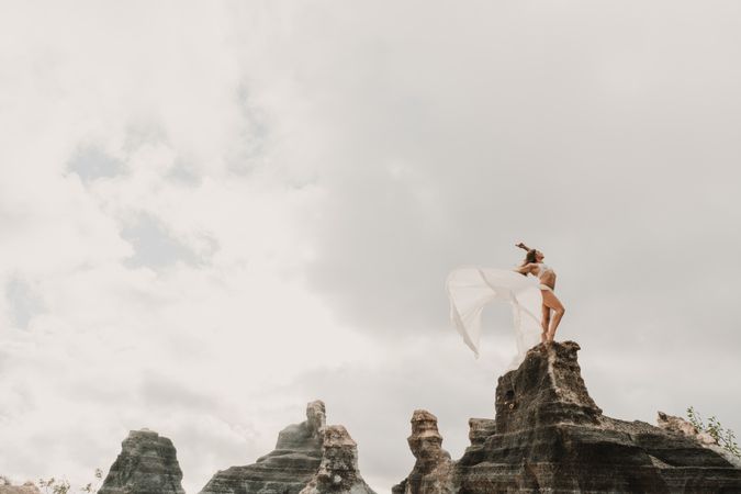 Anonymous female exercising on top of rock