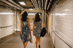 Back view of two women walking in hallway 0WJypb