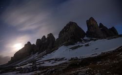 Dark mountains on white plain under starry sky