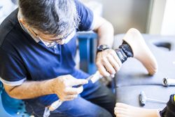 man fixing a prosthesis in a workshop