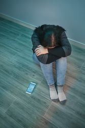 Unrecognizable desperate woman with phone addiction covering her face