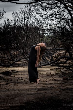 Woman dancing between dry trees