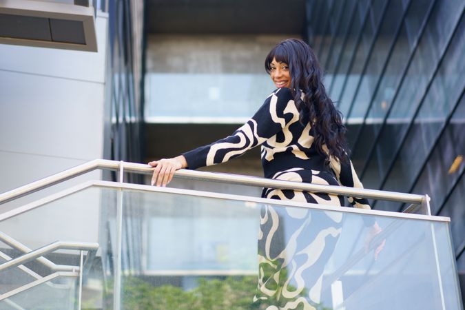 Sensual dancer turning to look down from urban viewpoint