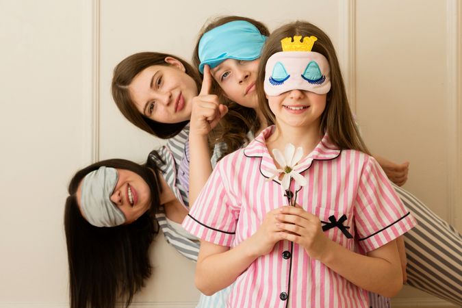 Girls peeking from behind another girl
