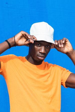 Black man in bright sporty outfit and cap