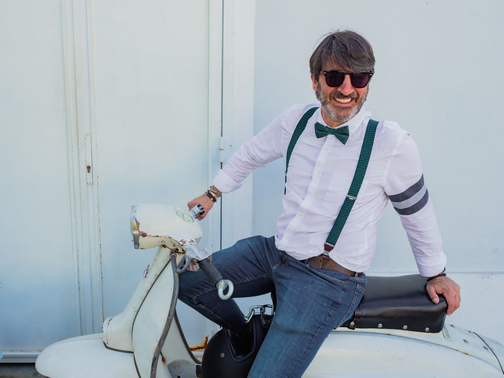 Trendy man sitting on vintage scooter