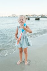 Cute little holding bottle of soap bubbles at beach