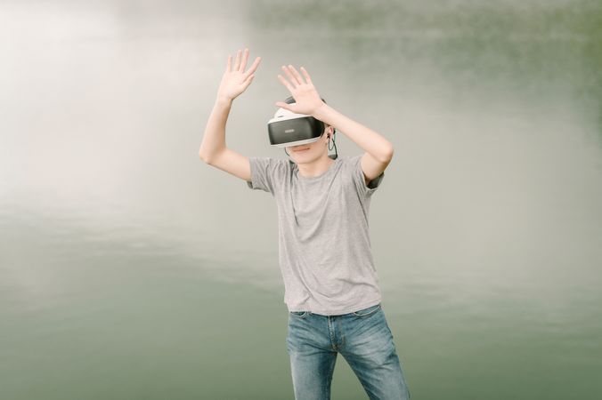 Young teenager with virtual reality glasses outdoors