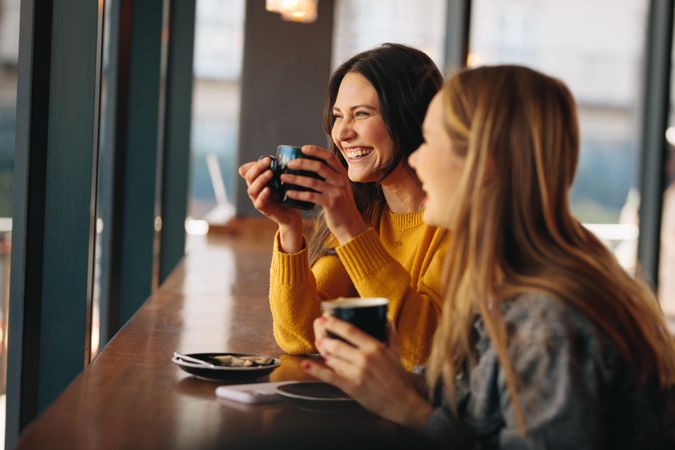 Two women having coffee and smiling
